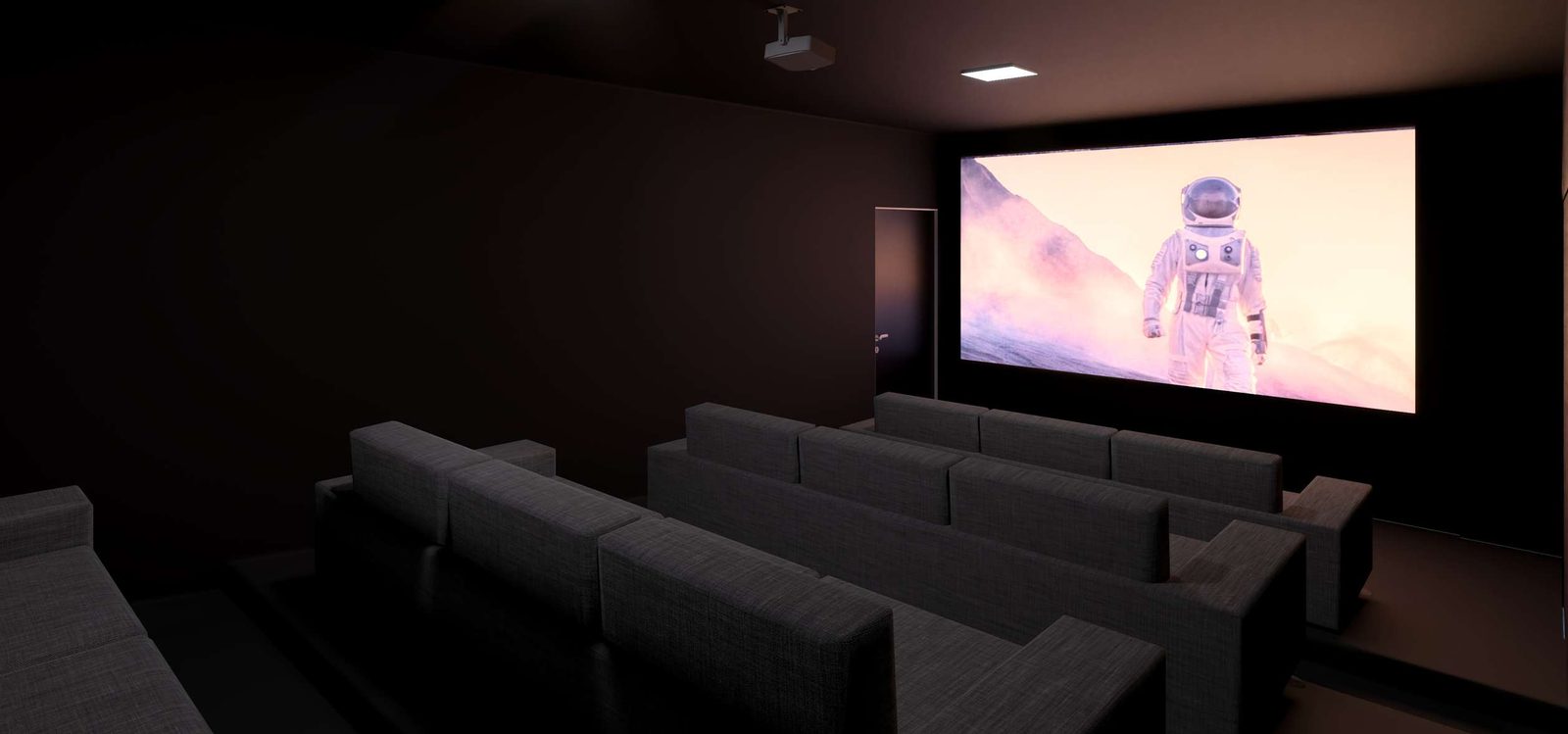 Sala de cinema do condomínio com poltronas escalonadas e tela ampla.